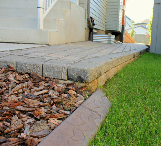 Brick paver walkway with mulch and concrete curb
